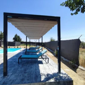 Pérgola 100x100 en tonos grises en terraza con piscina y tumbonas