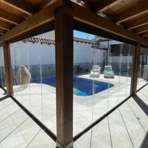 Cortina Cristal Abatible ONE en una casa con espacio abierto y piscina